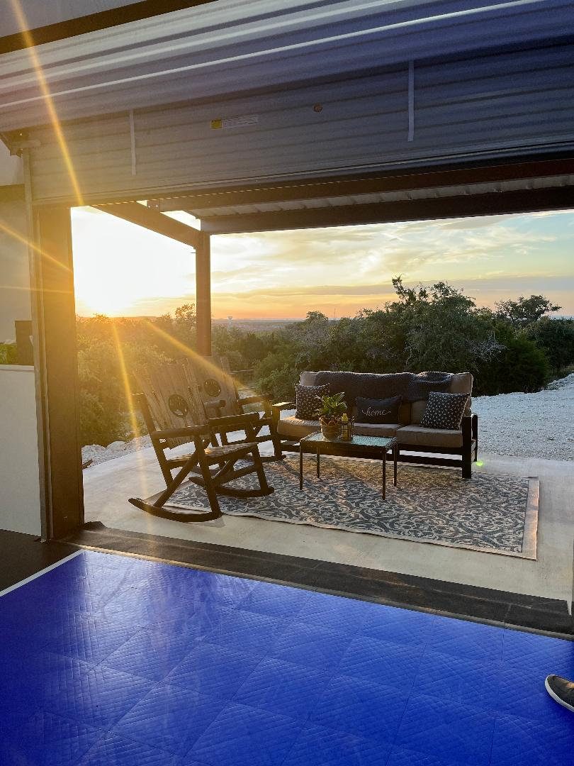 Covered patio with Hill Country view next to the court